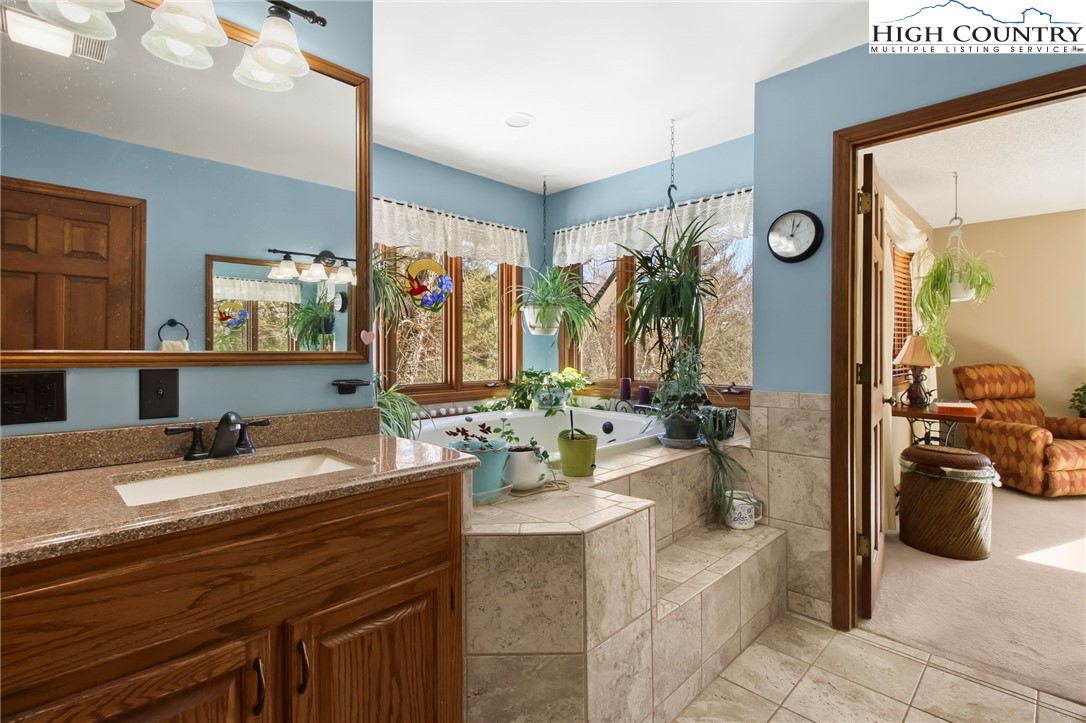 454 Huckleberry Trail Boone, NC 28607 - Photo 17 of 36 a bathroom with a granite countertop sink and a mirror