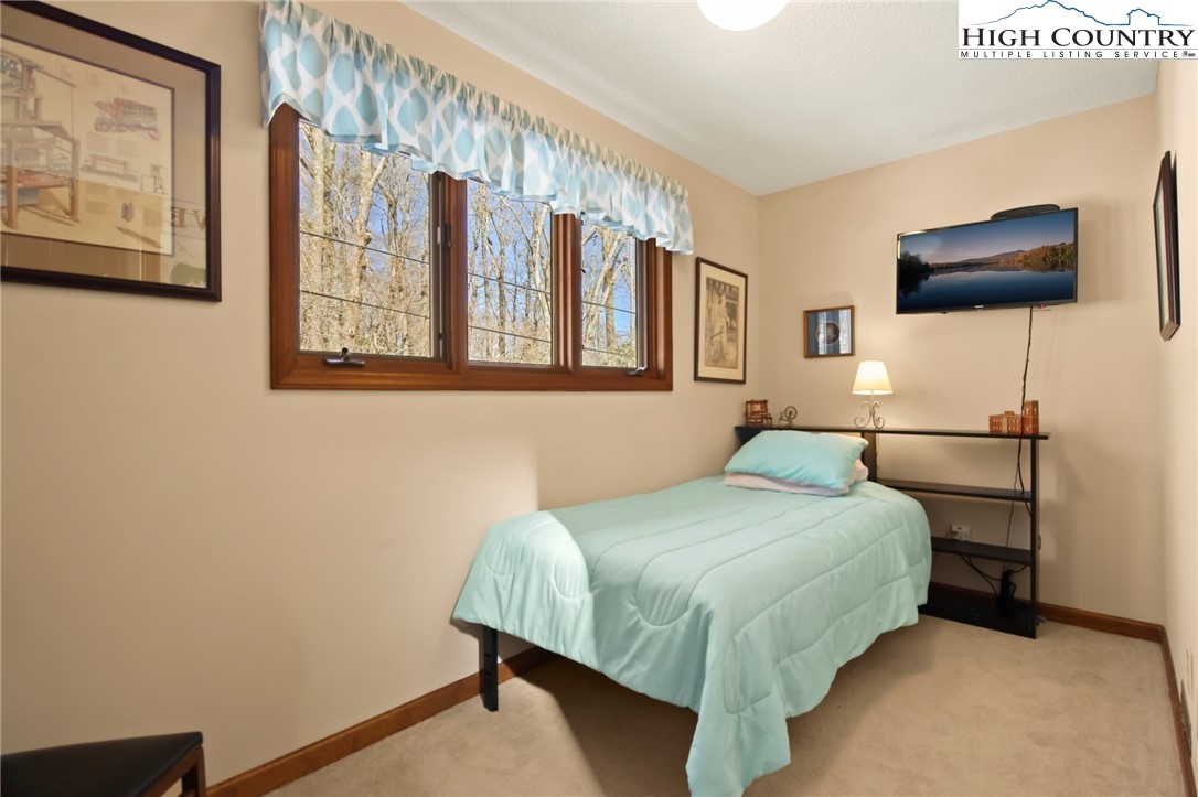 454 Huckleberry Trail Boone, NC 28607 - Photo 21 of 36 a bedroom with a bed and a flat screen tv