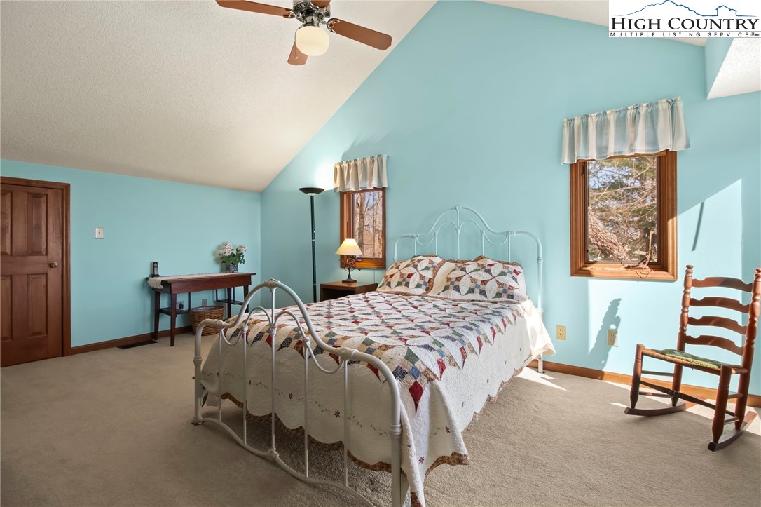 454 Huckleberry Trail Boone, NC 28607 - Photo 22 of 36 a bedroom with a bed and a chandelier