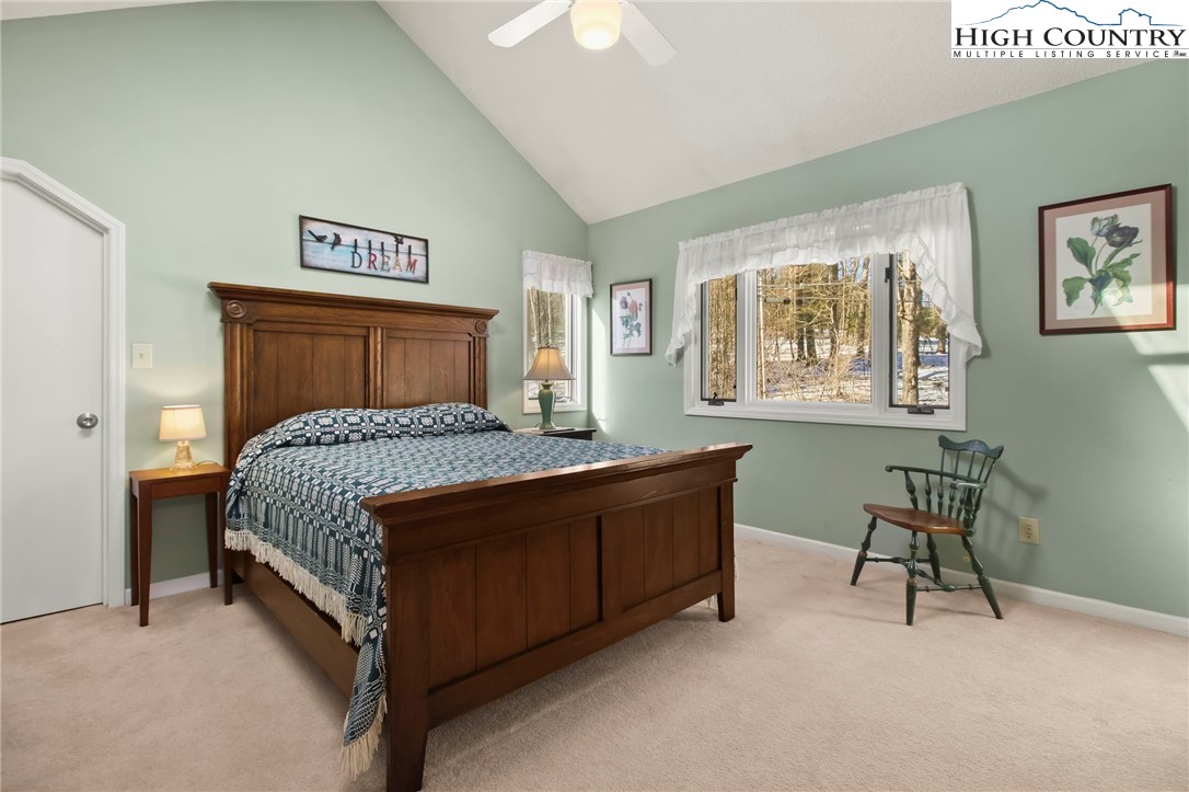 454 Huckleberry Trail Boone, NC 28607 - Photo 25 of 36 a bedroom with a bed and a chandelier