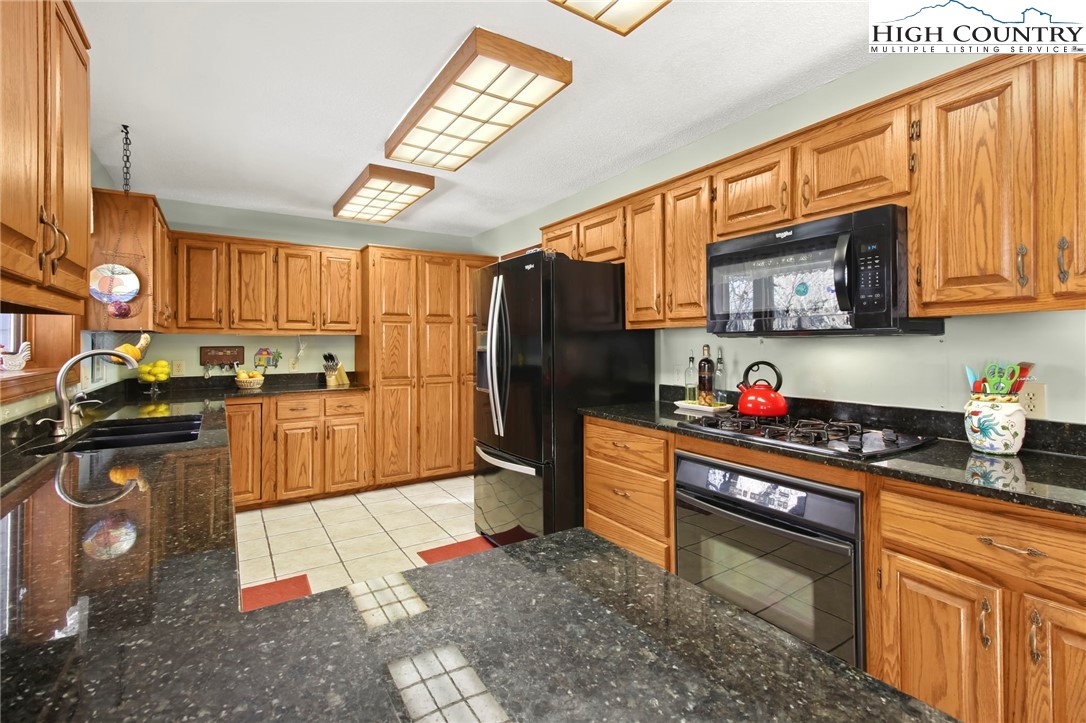 454 Huckleberry Trail Boone, NC 28607 - Photo 9 of 36 a kitchen with stainless steel appliances granite countertop a refrigerator stove and sink