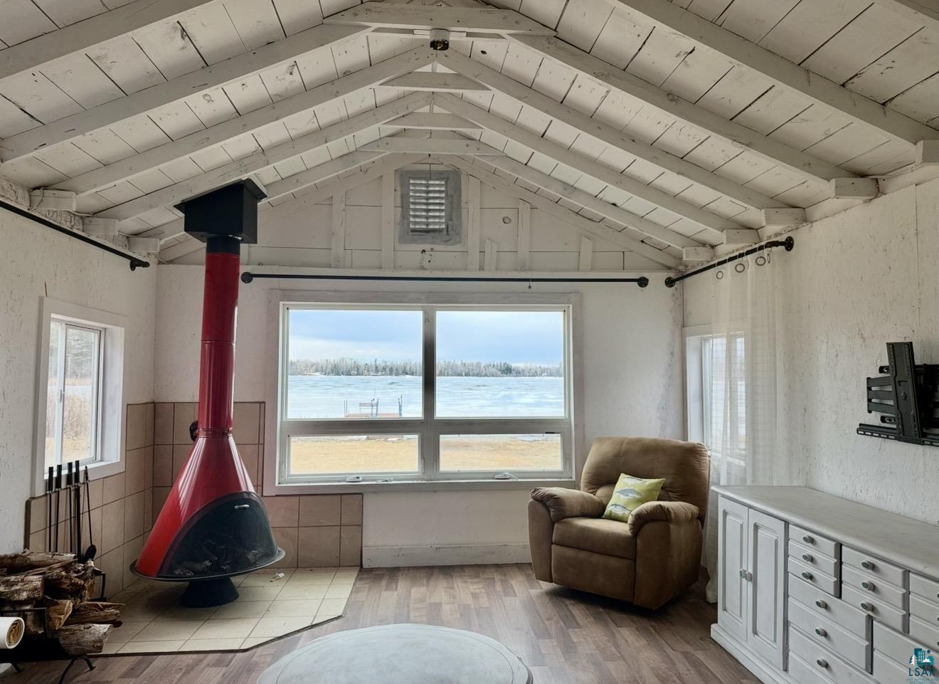9572 Bonner Road Mountain Iron, MN 55768 - Photo 2 of 20 Sitting room with a wood ceiling with exposed beams, light wood finished floors, plenty of natural light, a wood stove, and a water view
