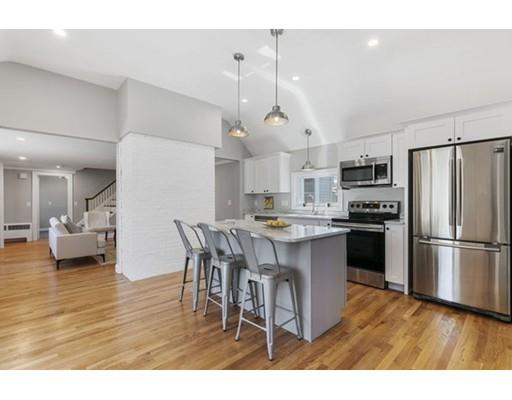 2 Abbott Road Natick, MA 01760 - Photo 3 of 23 a kitchen with stainless steel appliances kitchen island a refrigerator a stove a sink dishwasher and a dining table with wooden floor
