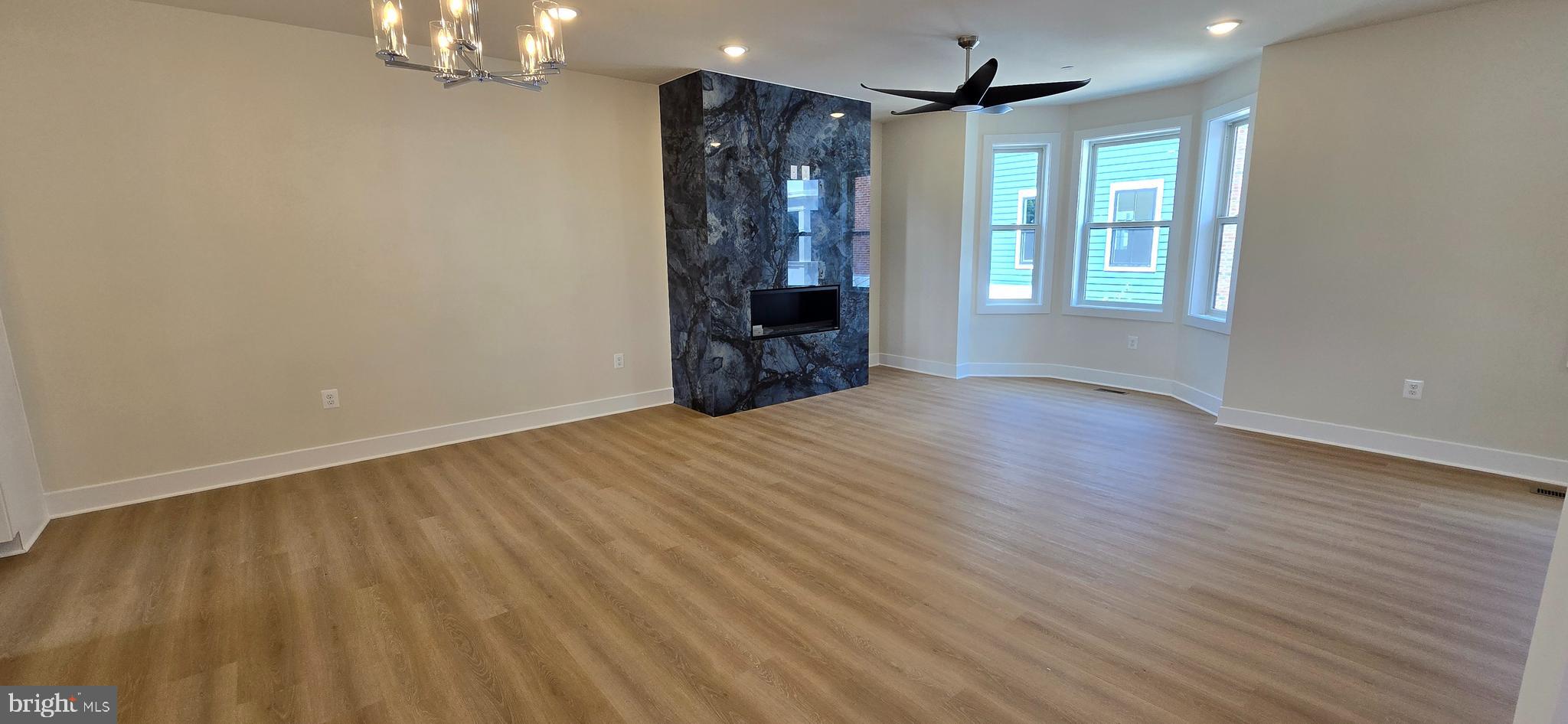 416 Chapel Alley, Unit 3 Frederick, MD 21701 - Photo 8 of 41 a view of an empty room with wooden floor and windows
