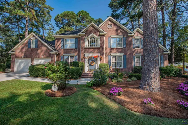 a front view of a house with a yard and potted plants