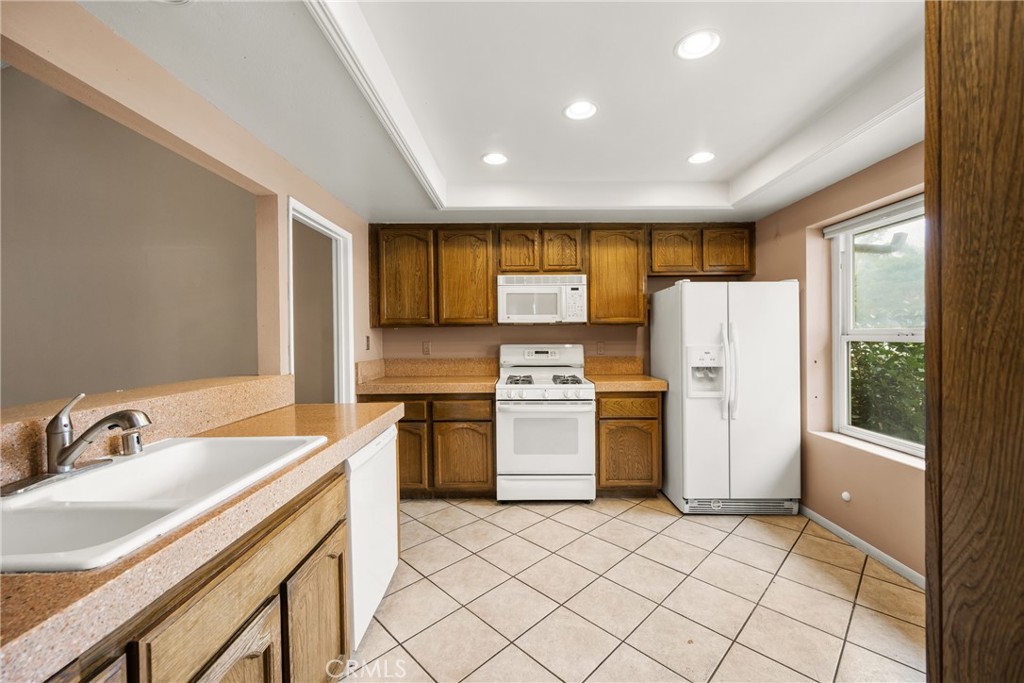 10 Greenbriar, Unit 31 Irvine, CA 92604 - Photo 14 of 46 a kitchen with a refrigerator a sink and a stove top oven