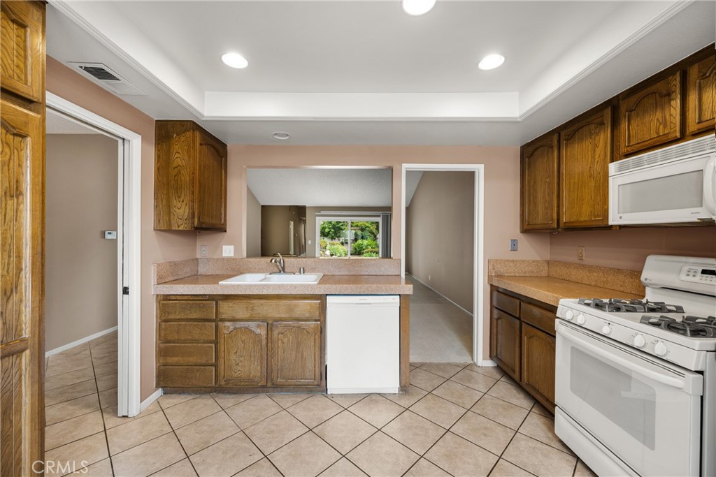 10 Greenbriar, Unit 31 Irvine, CA 92604 - Photo 16 of 46 a kitchen with a stove a sink and a refrigerator