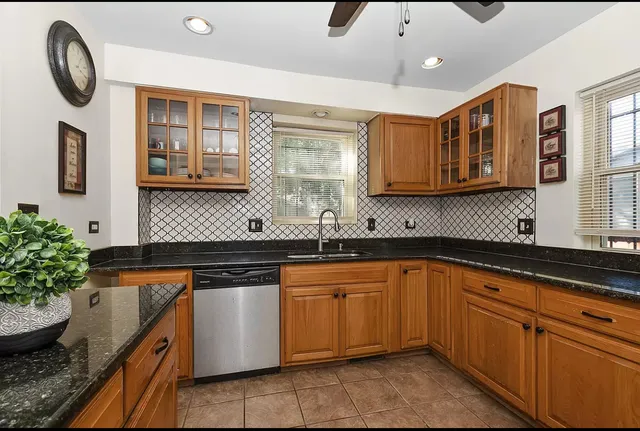 a kitchen with granite countertop stainless steel appliances a sink and a stove