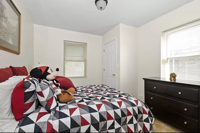 a bedroom with two bed and a window