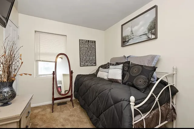 a bed room with a bed and a painting on the wall