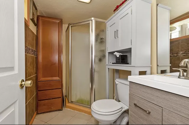a bathroom with a granite countertop toilet sink and shower