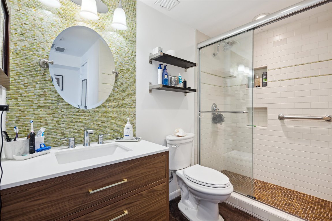 1801 Lavaca Street, Unit 11A Austin, TX 78701 - Photo 6 of 21 a bathroom with a toilet a sink and mirror