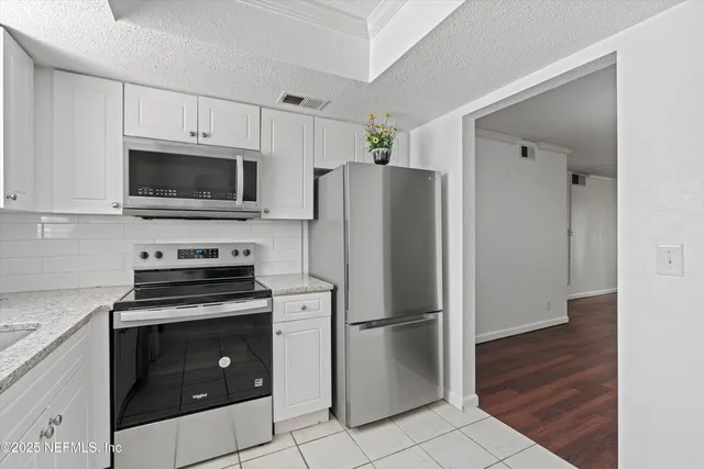 a kitchen with a refrigerator stove and microwave