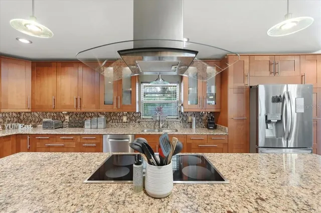 a kitchen with a refrigerator and a view of living room