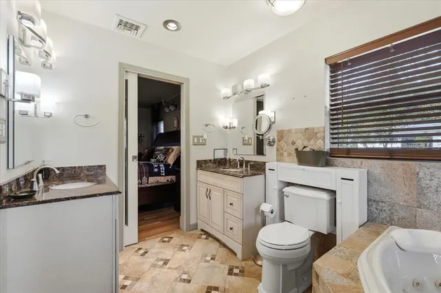 a bathroom with a sink toilet vanity and tub