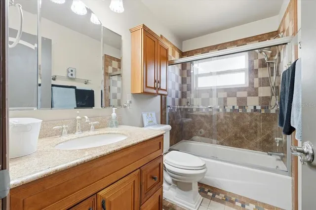 a bathroom with a granite countertop sink toilet and shower