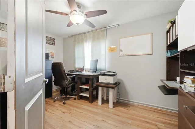 a view of a workspace with furniture and a window