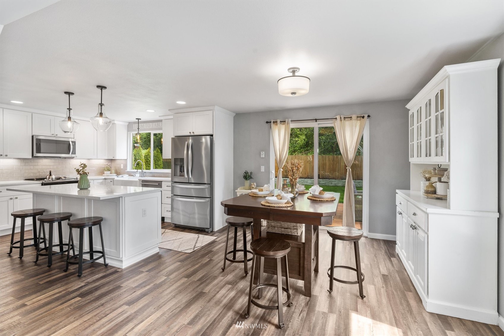 1208 228th Place Southwest Bothell, WA 98021 - Photo 3 of 33 a kitchen with a table chairs refrigerator and cabinets