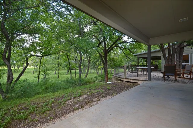 a view of a patio with table and chairs and floor to ceiling window