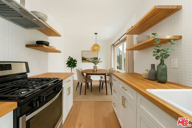 a kitchen with a stove and a dining table