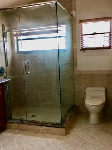 a bathroom with a toilet and a shower