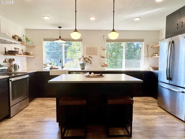a kitchen with a sink appliances and a large window