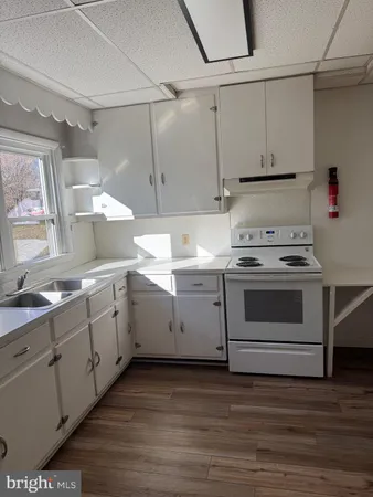 a kitchen with cabinets appliances and wooden floor