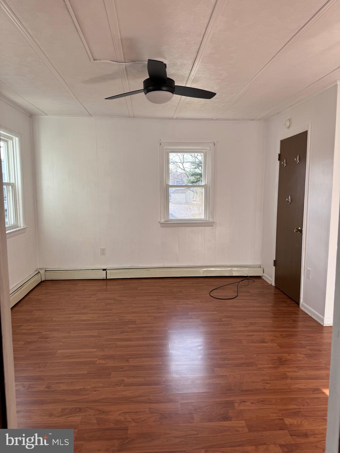 252 West State Street Quarryville, PA 17566 - Photo 6 of 9 an empty room with wooden floor and windows