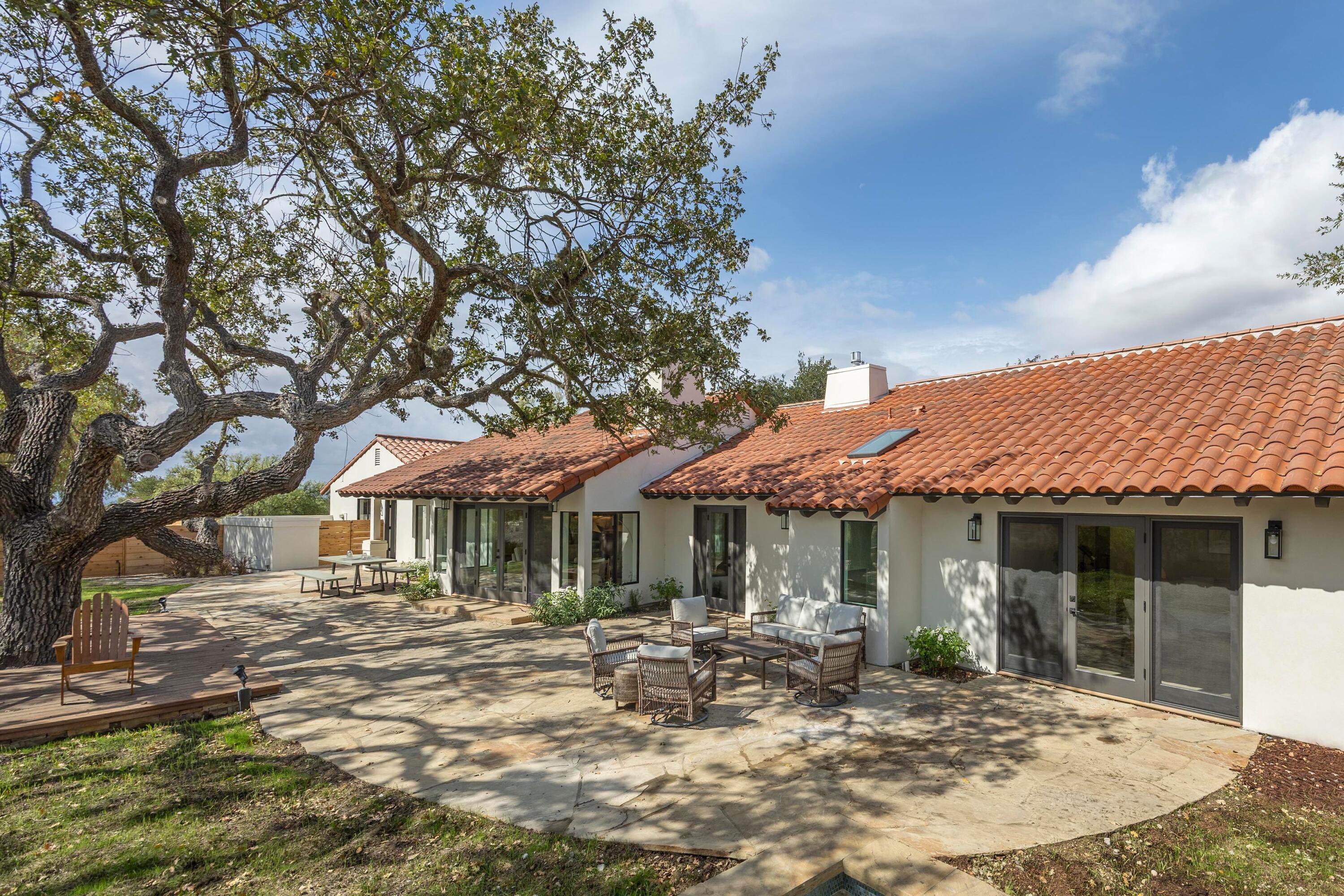 3009 Woodstock Road Santa Ynez, CA 93460 - Photo 4 of 32 a patio with a table and chairs under an umbrella