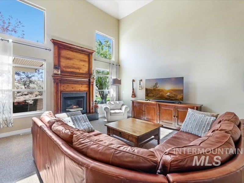 3408 Ridge Line Drive Kimberly, ID 83341 - Photo 12 of 37 Living room with a towering ceiling, carpet, a fireplace, and plenty of natural light