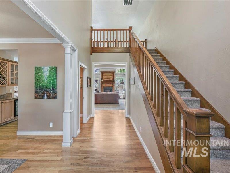 3408 Ridge Line Drive Kimberly, ID 83341 - Photo 7 of 37 Foyer entrance featuring light wood-style floors, ornate columns, stairway, crown molding, and a high ceiling