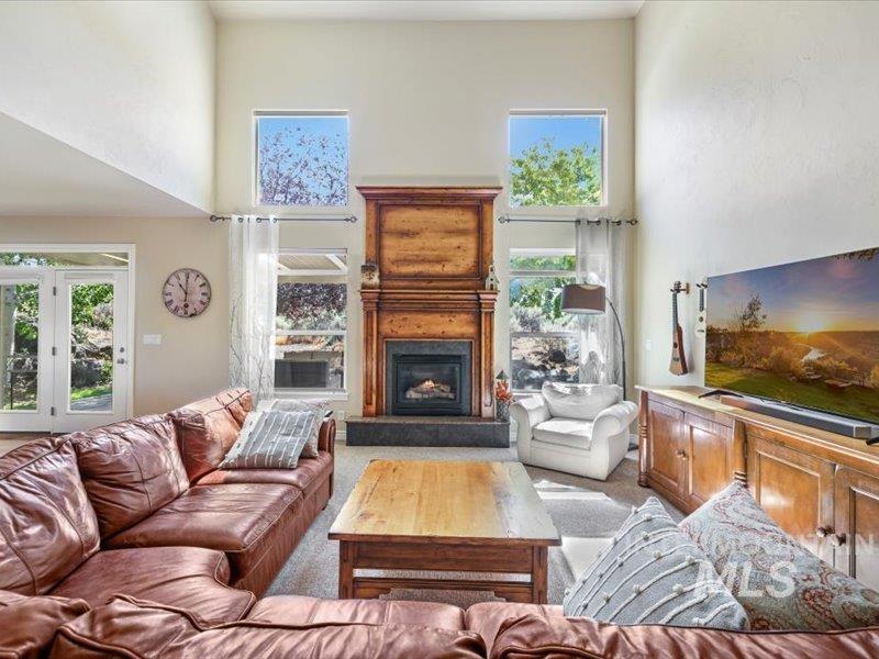 3408 Ridge Line Drive Kimberly, ID 83341 - Photo 8 of 37 Living area with a towering ceiling, a warm lit fireplace, and light carpet
