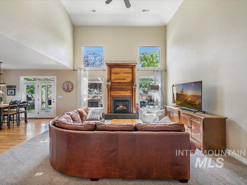 3408 Ridge Line Drive Kimberly, ID 83341 - Photo 9 of 37 Carpeted living room featuring a high ceiling, a ceiling fan, a glass covered fireplace, and french doors