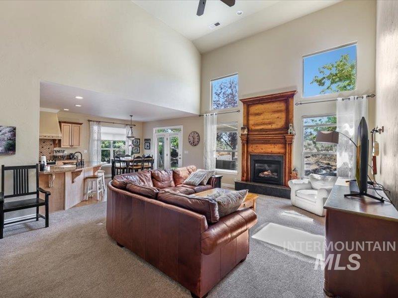 3408 Ridge Line Drive Kimberly, ID 83341 - Photo 10 of 37 Living room with light colored carpet, a high ceiling, ceiling fan, a glass covered fireplace, and recessed lighting