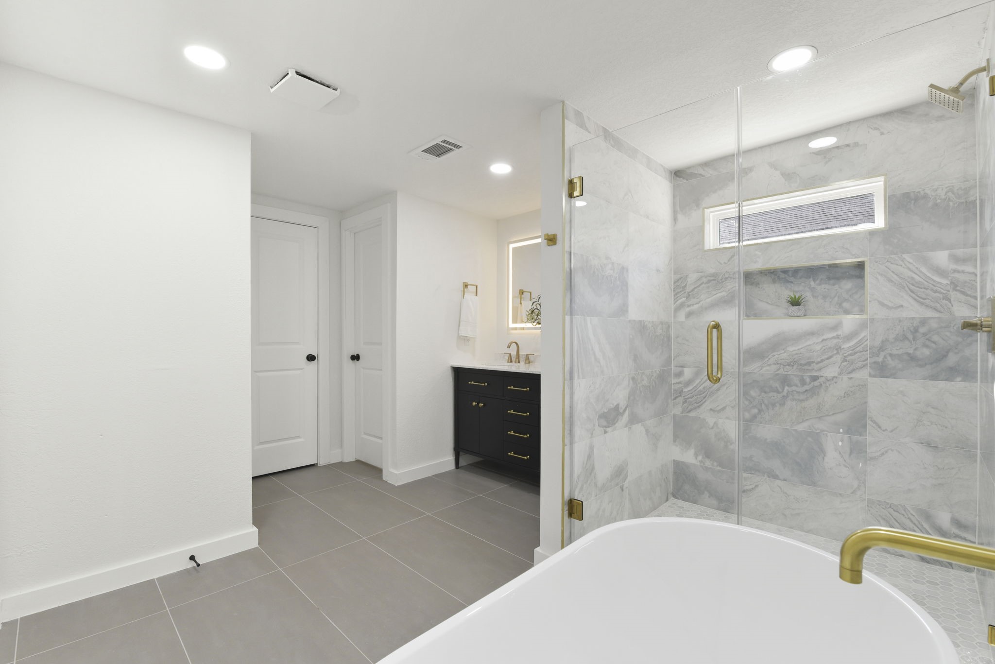 1630 1/2 Tabor Street Houston, TX 77009 - Photo 18 of 28 a bathroom with a tub a sink a mirror and a shower