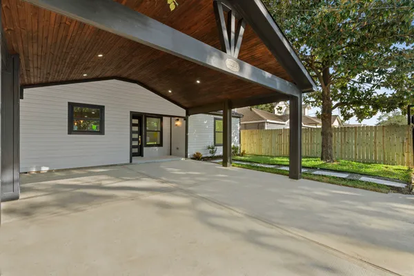 a view of a house with a small yard and wooden fence