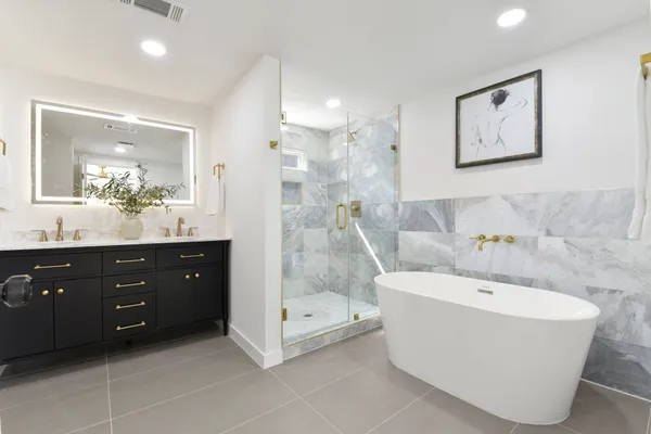 a large kitchen with stainless steel appliances kitchen island granite countertop a stove a sink a refrigerator and white cabinets with wooden floor