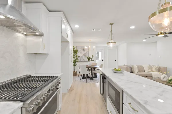 a kitchen with a stove a sink a refrigerator and cabinets