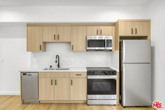 a kitchen with stainless steel appliances a stove microwave and sink