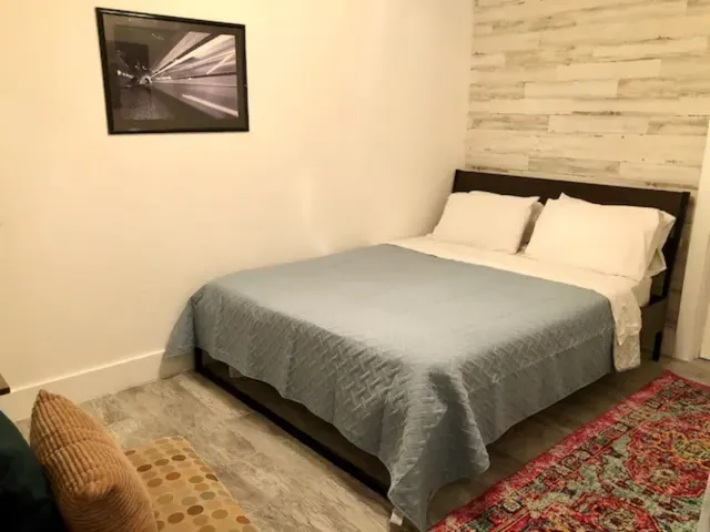 a bedroom with a bed and a painting on the wall