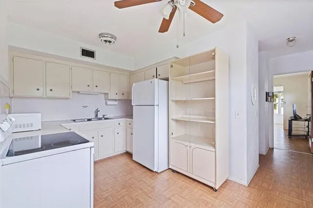 a kitchen with cabinets appliances a sink and a counter top