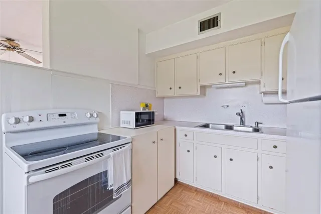 a utility room with refrigerator stove and wooden floor