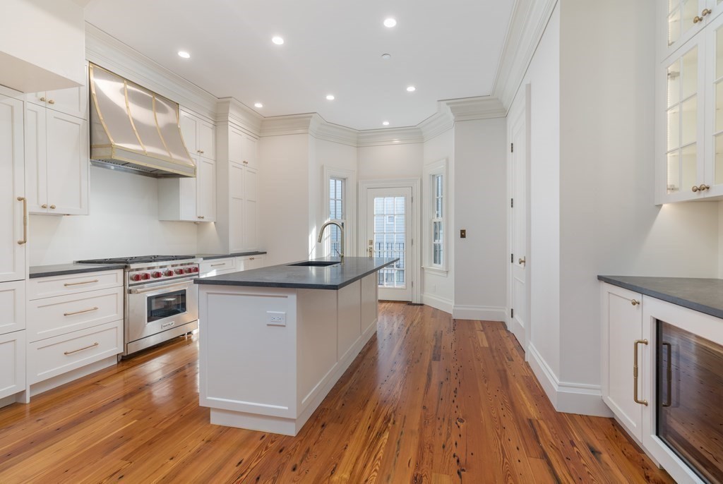 793 East 4th Street Boston, MA 02127 - Photo 3 of 17 a kitchen with granite countertop white cabinets and white appliances