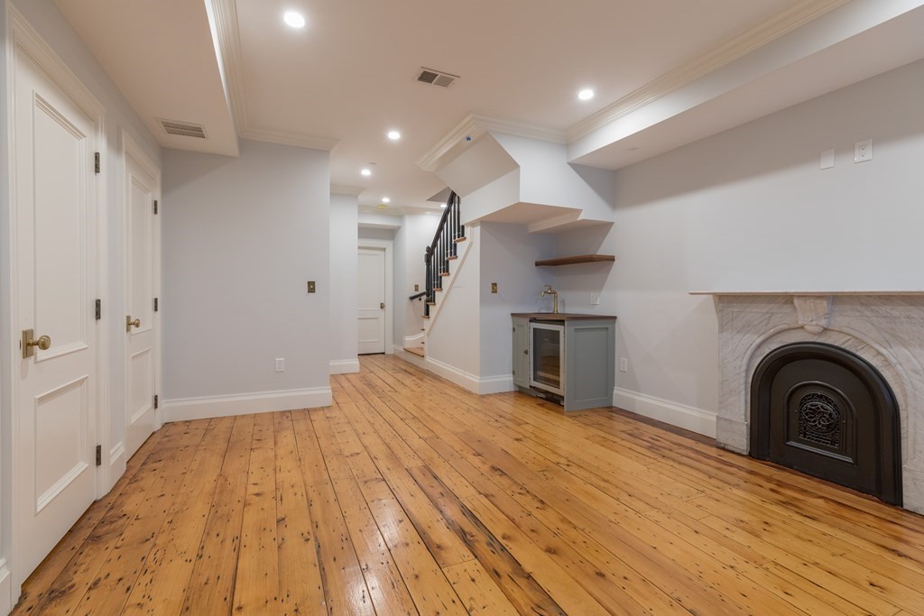 793 East 4th Street Boston, MA 02127 - Photo 4 of 17 a view of empty room with wooden floor and fireplace