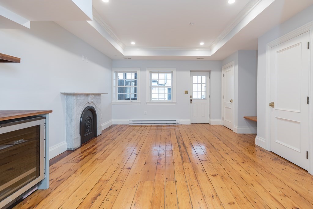 793 East 4th Street Boston, MA 02127 - Photo 5 of 17 a view of empty room with wooden floor and fireplace