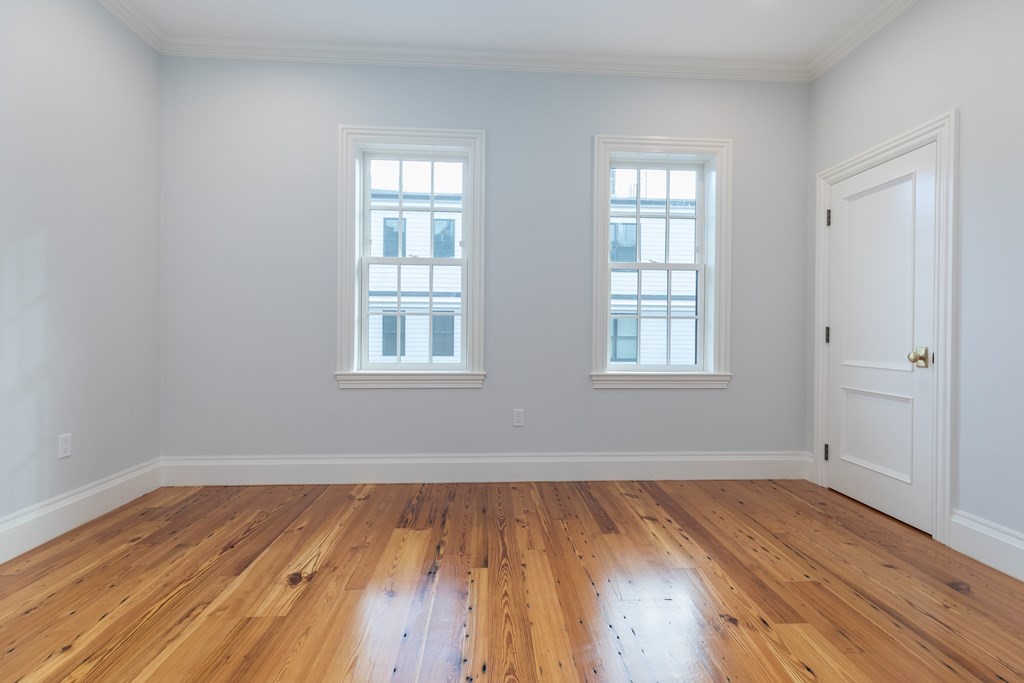 793 East 4th Street Boston, MA 02127 - Photo 9 of 17 an empty room with wooden floor and windows
