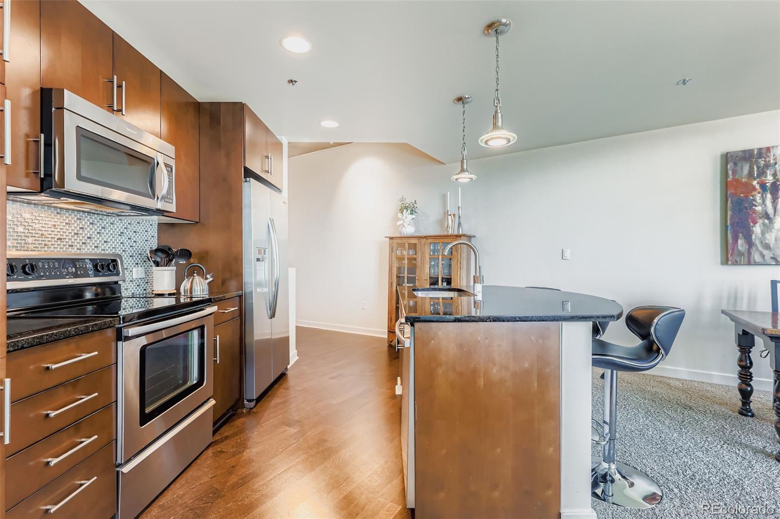 891 14th Street, Unit 1111L Denver, CO 80202 - Photo 5 of 39 a kitchen with stainless steel appliances granite countertop a stove a sink and a refrigerator