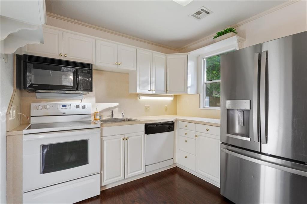 410 Rice Avenue Waco, TX 76708 - Photo 34 of 40 a kitchen with cabinets stainless steel appliances and wooden floor
