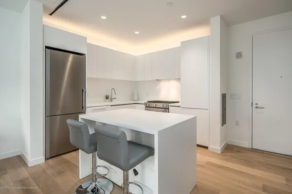 a kitchen with a refrigerator a sink and a stove top oven