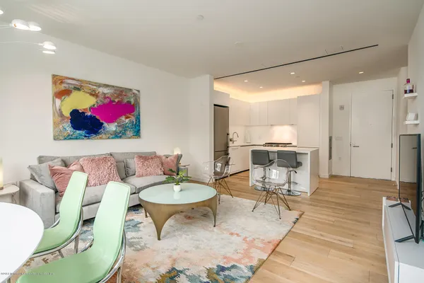 a living room with furniture and a dining table with kitchen view